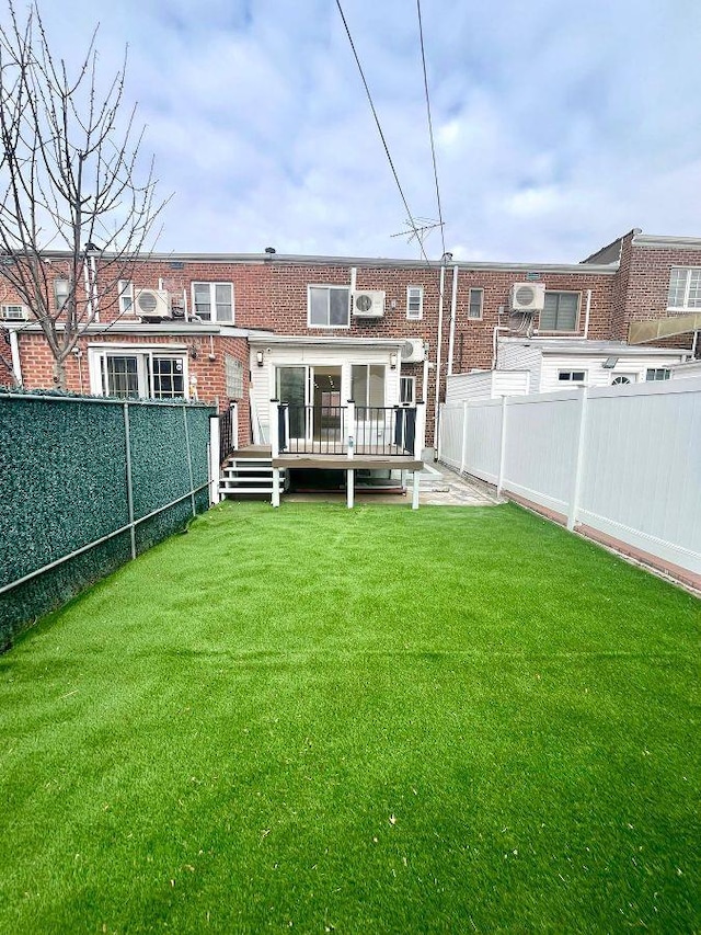 back of house featuring a yard and a wooden deck