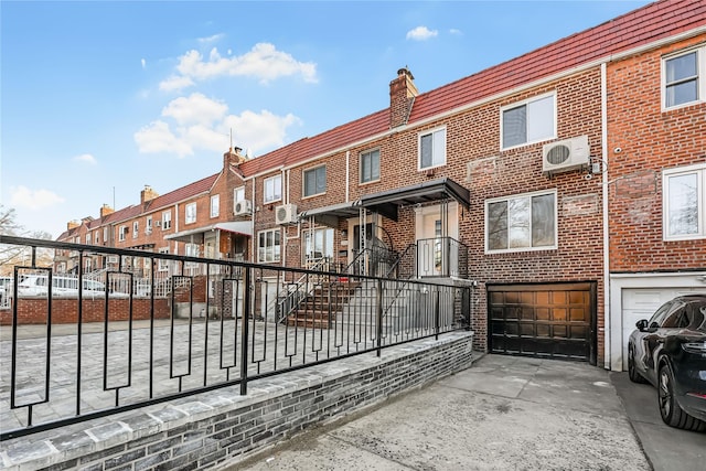 view of gate with a garage and ac unit