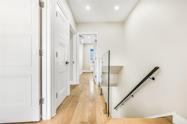 hall featuring light wood-type flooring and an AC wall unit