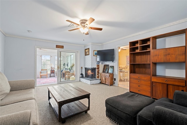 carpeted living room featuring a brick fireplace, ceiling fan, and crown molding