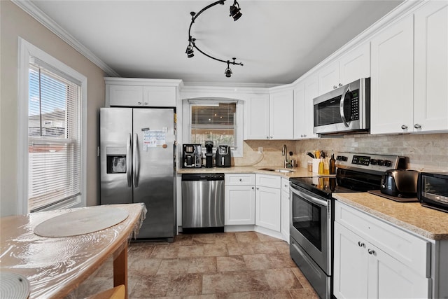 kitchen with crown molding, sink, white cabinets, and stainless steel appliances