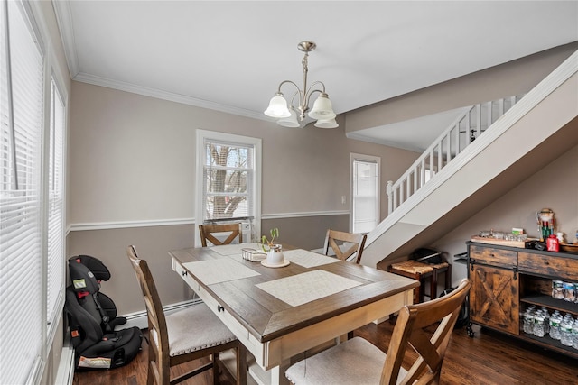 dining area featuring ornamental molding, dark wood-type flooring, and a chandelier