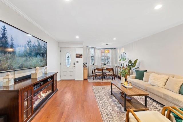 living room with ornamental molding and light wood-type flooring