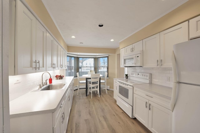 kitchen featuring backsplash, sink, white appliances, and white cabinetry