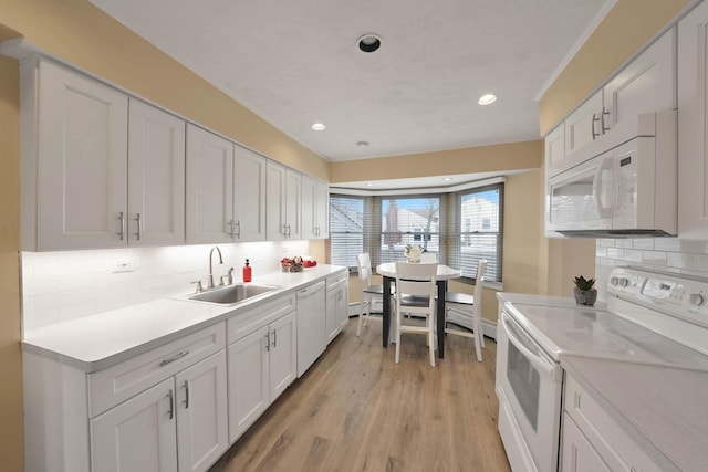 kitchen with white cabinetry, sink, white appliances, and backsplash