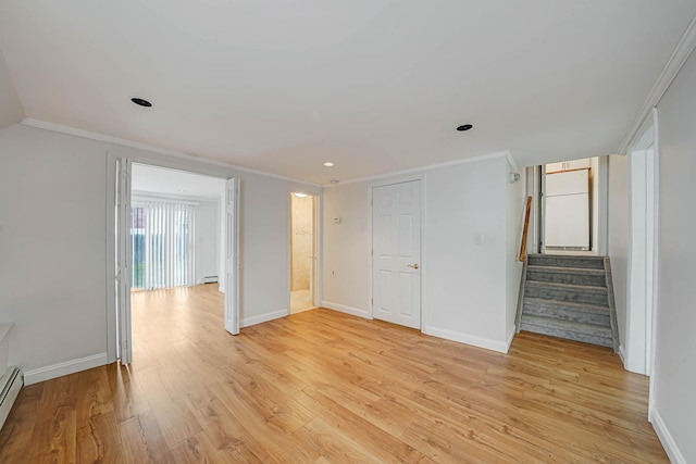 unfurnished room with a baseboard heating unit, crown molding, and light hardwood / wood-style flooring