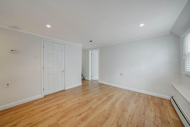 unfurnished room with a baseboard radiator, light hardwood / wood-style flooring, ornamental molding, and vaulted ceiling