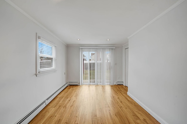 empty room featuring baseboard heating, light hardwood / wood-style flooring, and crown molding