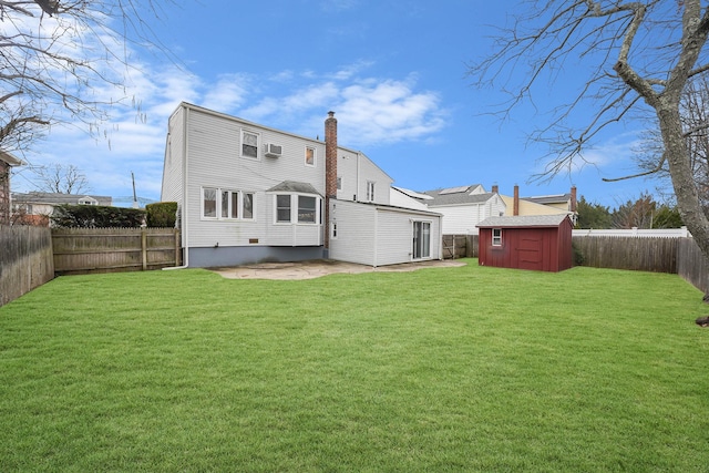 back of house with a storage shed, a lawn, and a patio