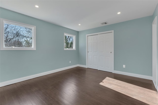 unfurnished bedroom with a closet and dark wood-type flooring