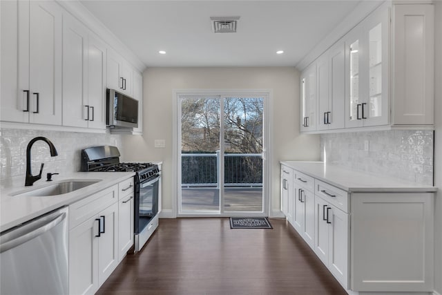 kitchen featuring sink, white cabinetry, appliances with stainless steel finishes, and tasteful backsplash