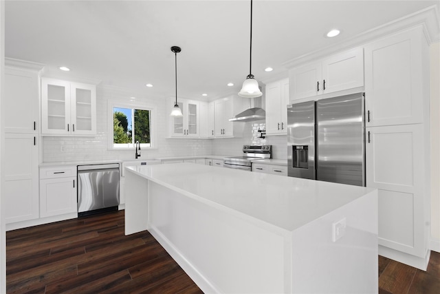 kitchen with pendant lighting, stainless steel appliances, dark hardwood / wood-style floors, white cabinets, and a kitchen island