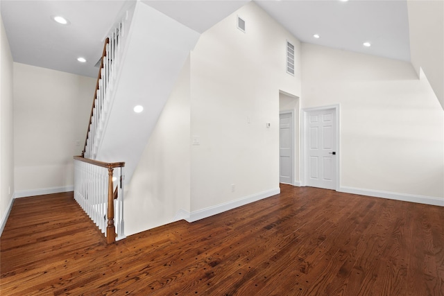 interior space featuring dark wood-type flooring and high vaulted ceiling