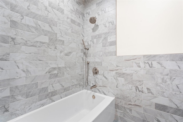 bathroom with tiled shower / bath and tile walls