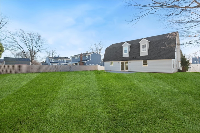 rear view of house featuring a yard and a patio