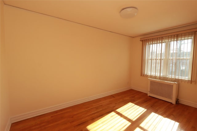 spare room with radiator and hardwood / wood-style flooring