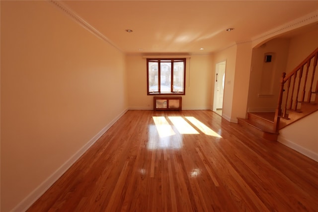 spare room featuring crown molding and wood-type flooring