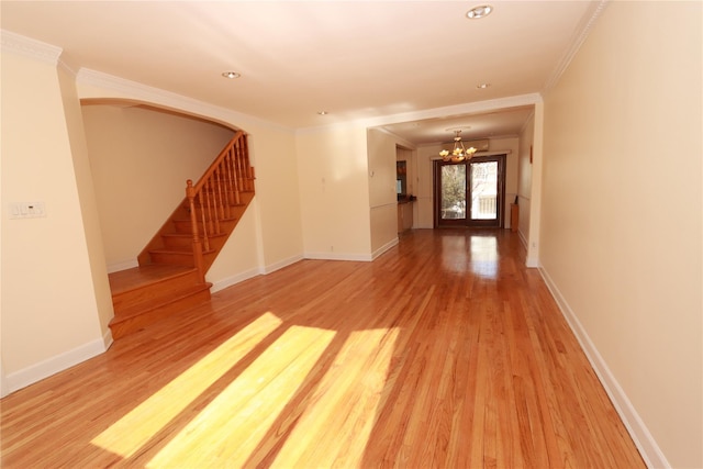 unfurnished room featuring hardwood / wood-style floors, a chandelier, and ornamental molding