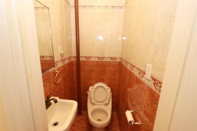 bathroom with tile walls, sink, and toilet