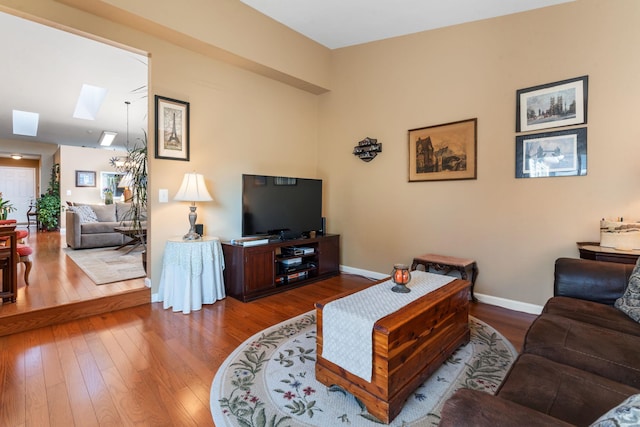 living room featuring a skylight and wood-type flooring