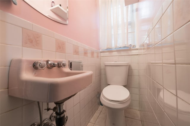 bathroom with tile patterned floors, toilet, and tile walls