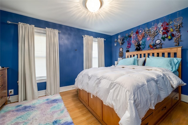 bedroom with light hardwood / wood-style floors and multiple windows