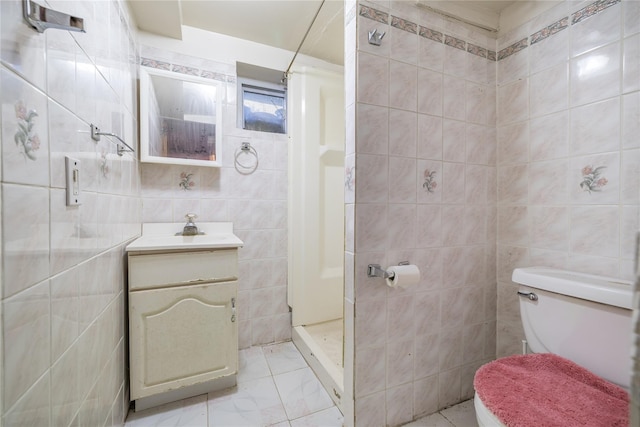 bathroom featuring toilet, vanity, walk in shower, and tile walls