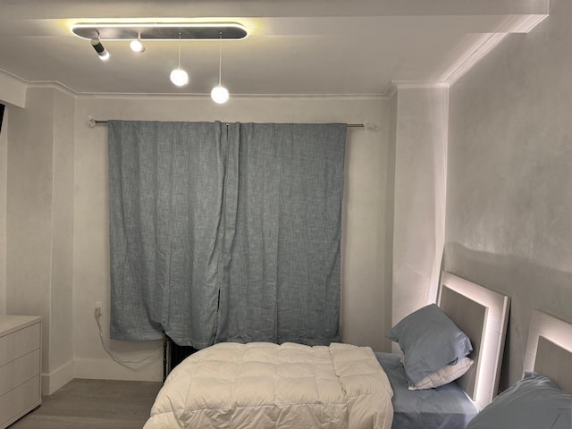 bedroom with wood-type flooring and crown molding