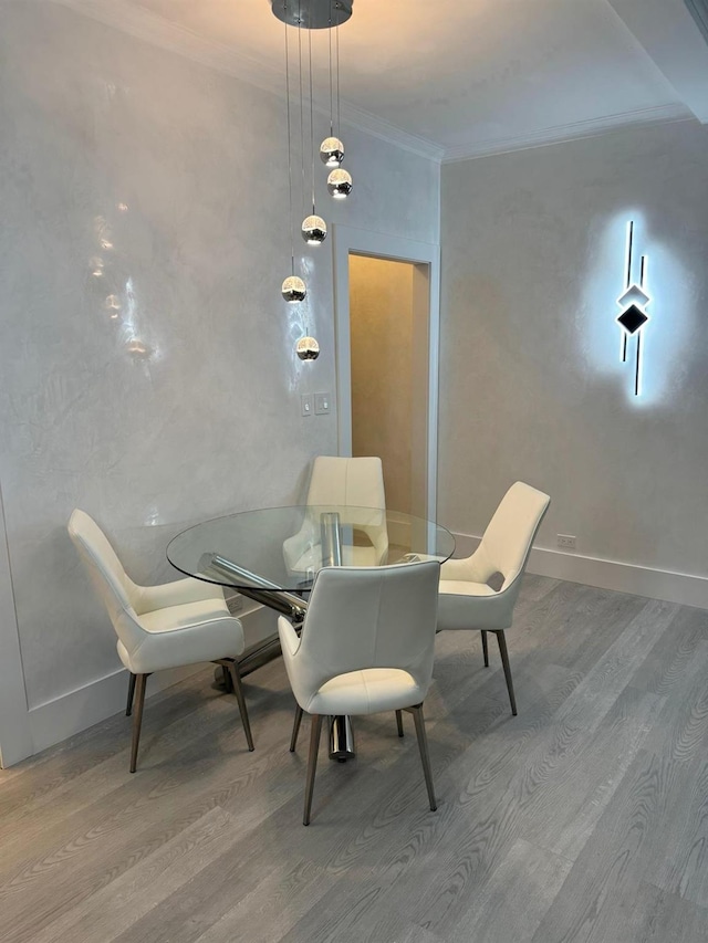 dining space with hardwood / wood-style floors and ornamental molding