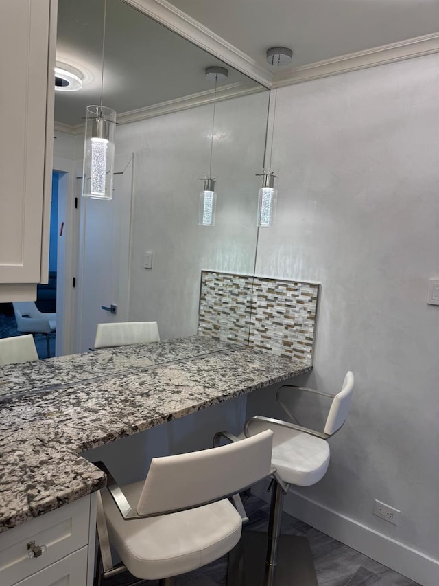 kitchen featuring stone countertops, white cabinetry, and hanging light fixtures