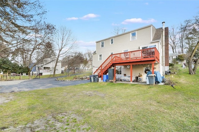 back of property featuring a deck and a yard