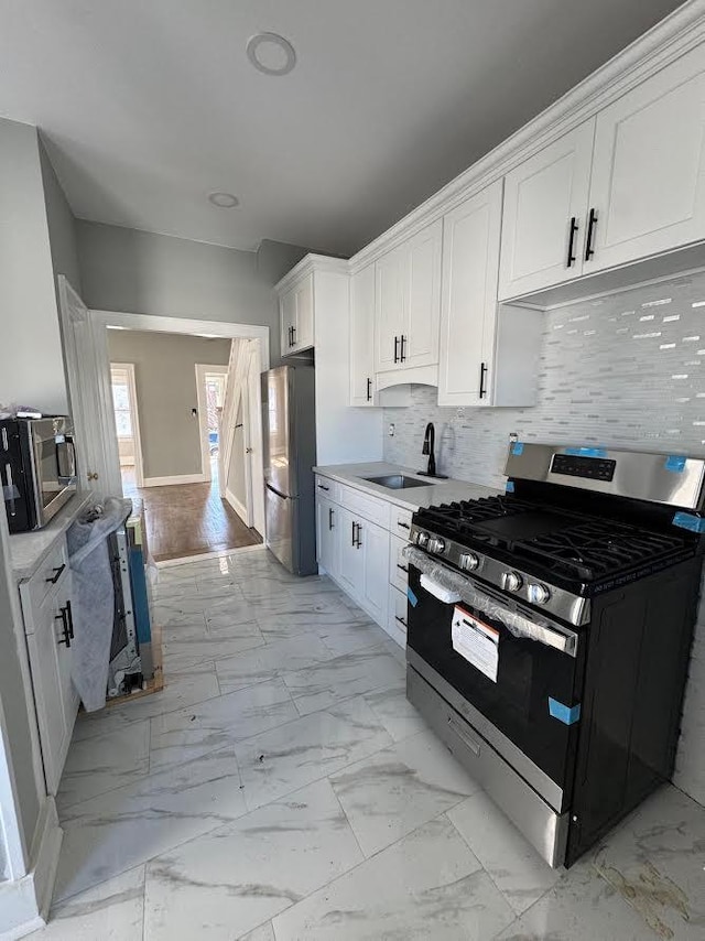 kitchen featuring appliances with stainless steel finishes, light countertops, marble finish floor, and white cabinets