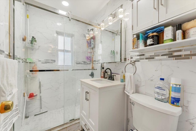 bathroom featuring toilet, vanity, tile walls, and walk in shower