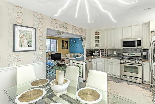 kitchen featuring white cabinets, appliances with stainless steel finishes, sink, and tasteful backsplash