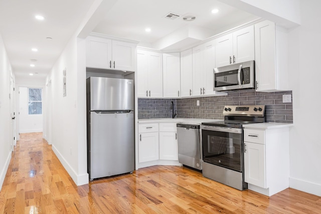 kitchen with white cabinetry, light hardwood / wood-style flooring, and appliances with stainless steel finishes