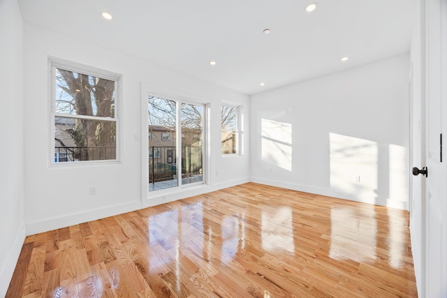 spare room featuring light hardwood / wood-style flooring and plenty of natural light