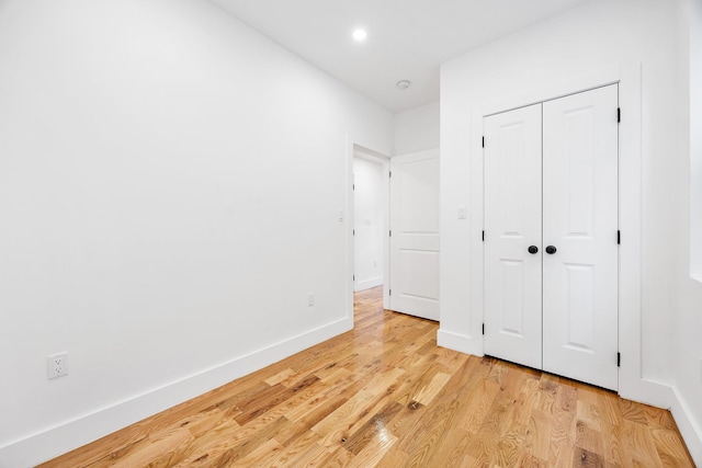 unfurnished bedroom featuring a closet and light hardwood / wood-style flooring