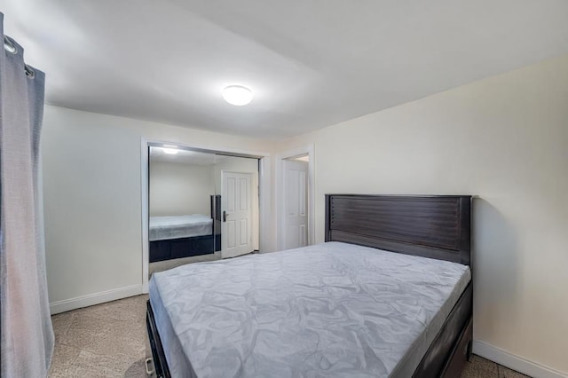 bedroom with light colored carpet and baseboards