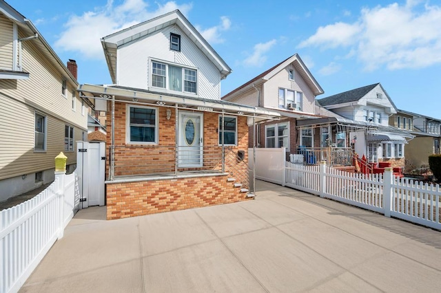 view of front of property with a fenced front yard and brick siding