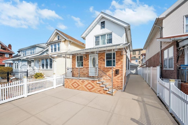 view of front of home featuring a fenced front yard, a porch, and brick siding