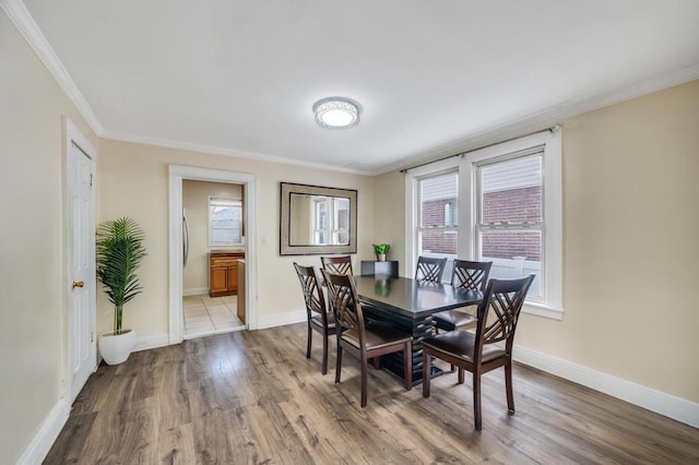 dining room featuring baseboards, ornamental molding, and wood finished floors