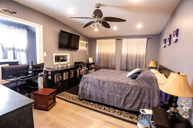 bedroom with a wall mounted air conditioner, ceiling fan, light hardwood / wood-style floors, and vaulted ceiling