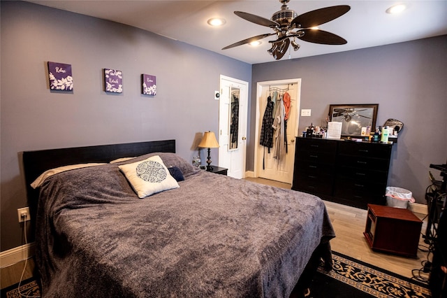 bedroom featuring ceiling fan, light hardwood / wood-style floors, and a closet