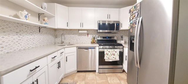 kitchen featuring sink, stainless steel appliances, white cabinets, and decorative backsplash