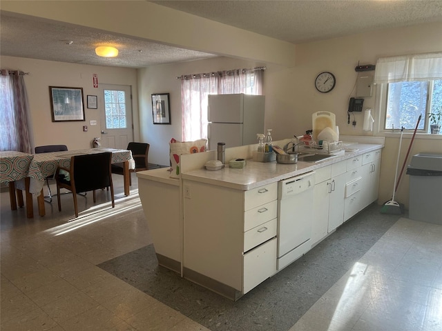 kitchen featuring sink, white appliances, white cabinets, and a textured ceiling