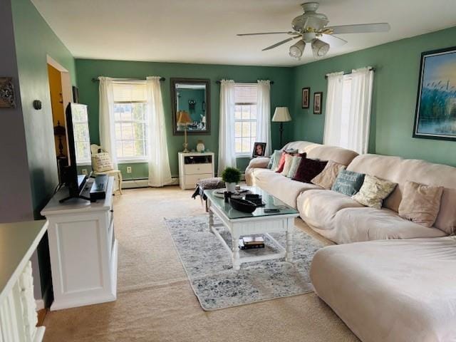 living room with a wealth of natural light, ceiling fan, and light carpet