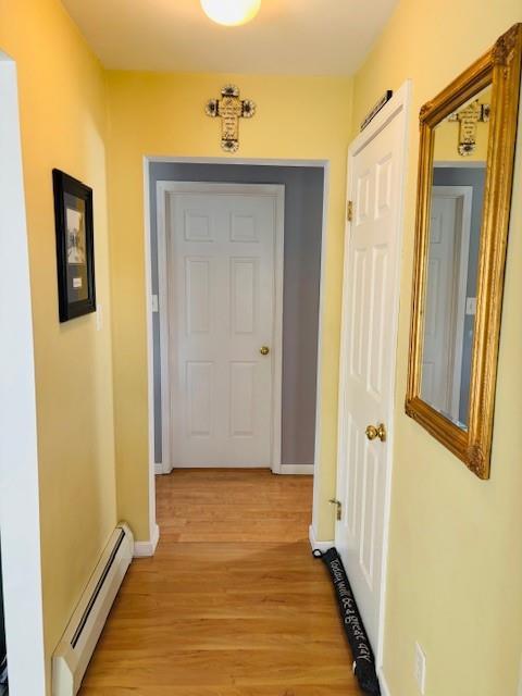 hallway featuring a baseboard radiator and light hardwood / wood-style flooring