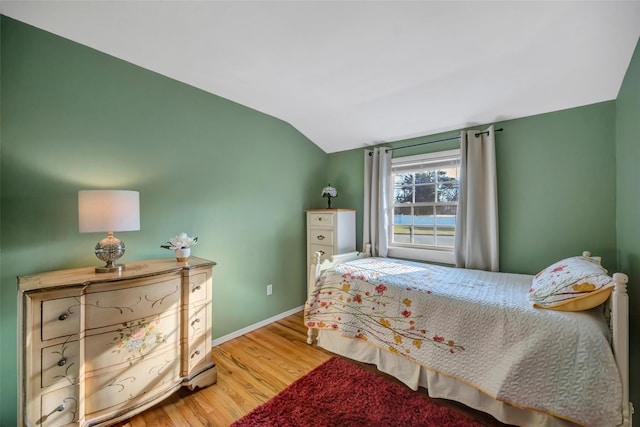 bedroom featuring hardwood / wood-style flooring and vaulted ceiling