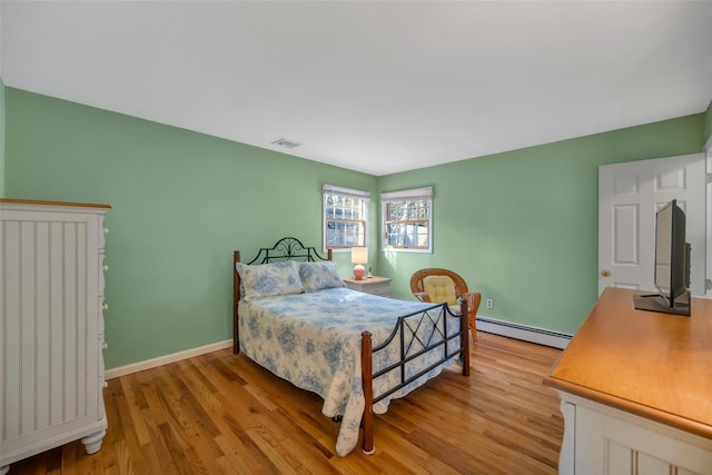 bedroom featuring a baseboard radiator and light hardwood / wood-style flooring