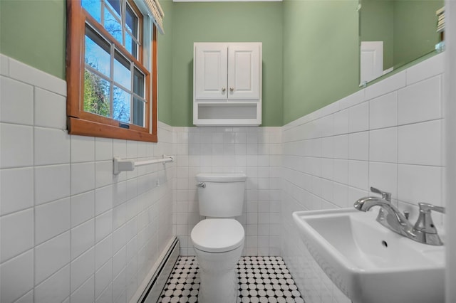 bathroom featuring tile patterned floors, sink, tile walls, and a baseboard radiator